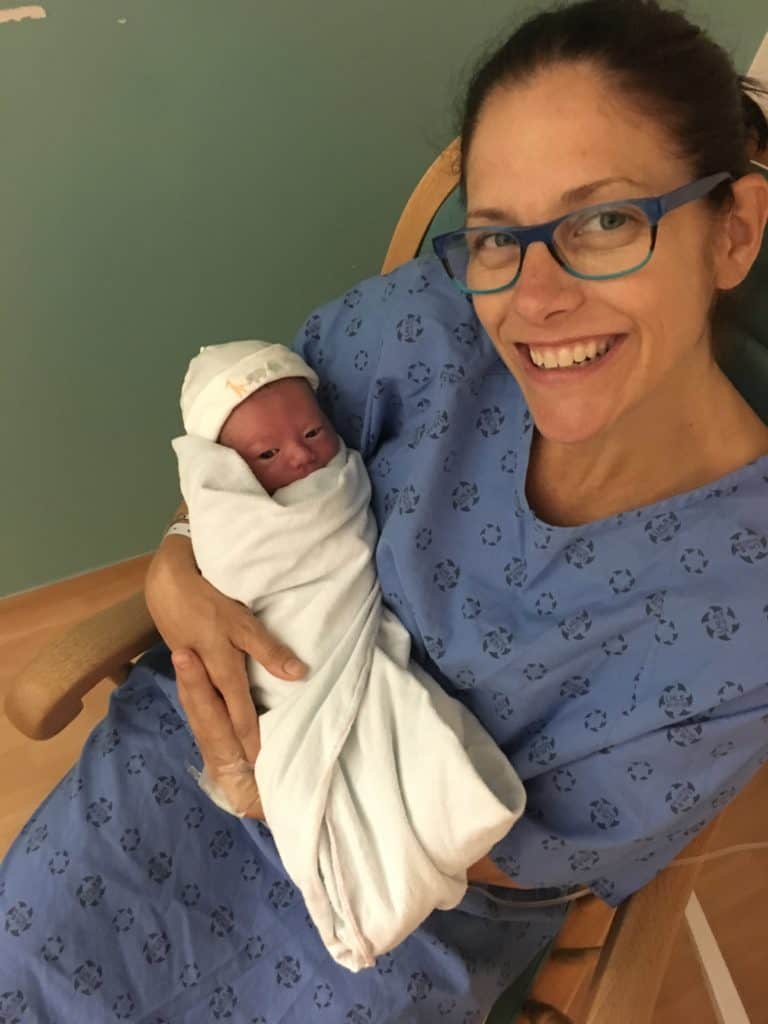 mom in hospital gown holding her newborn, lessons learned from my ivf journey