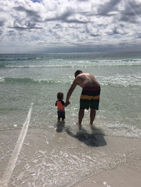 dad and infant son standing on a florida beach seeing the ocean for the first time, our ivf success story over 40
