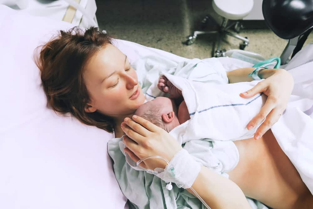 how to make labor easier and faster, woman holding newborn after labor