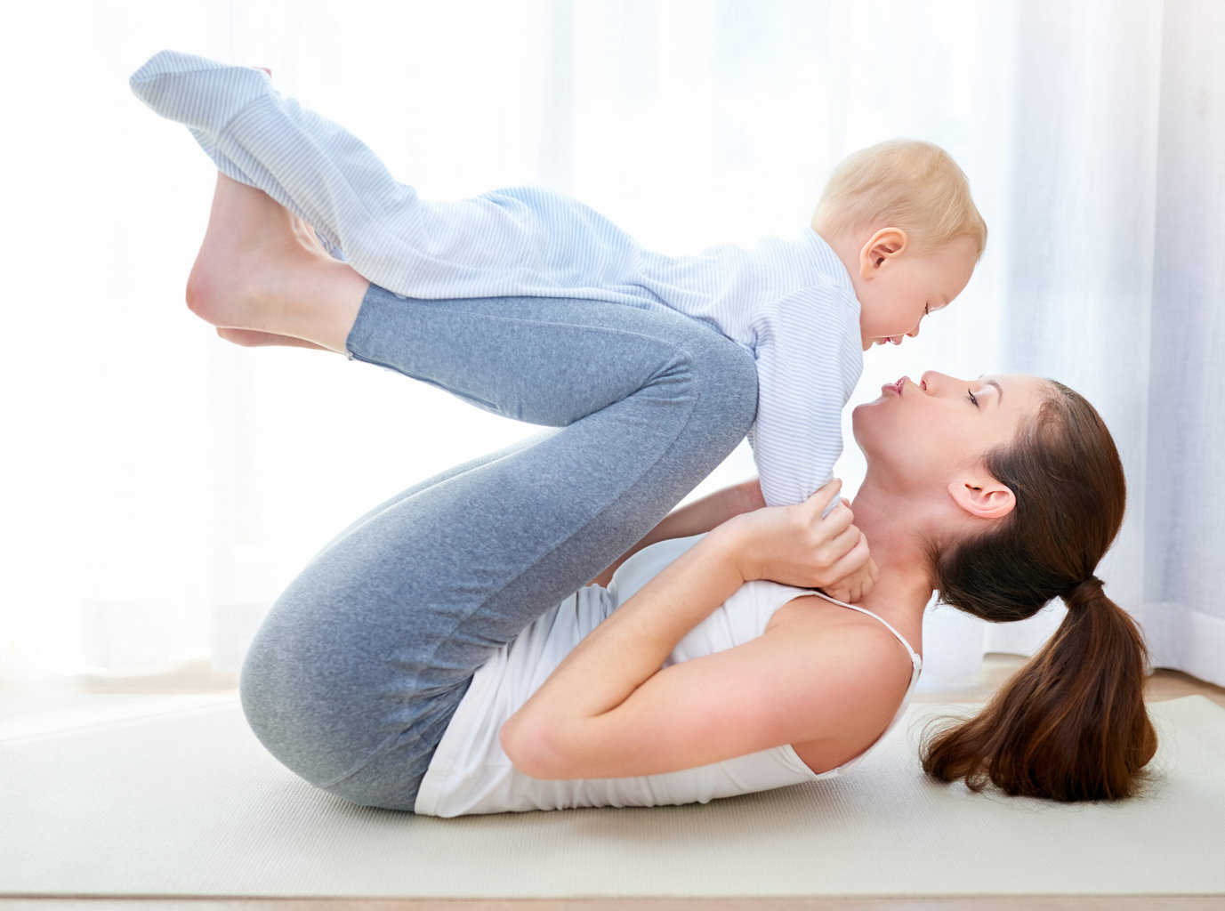 young mom and baby in yoga pose best postpartum pants