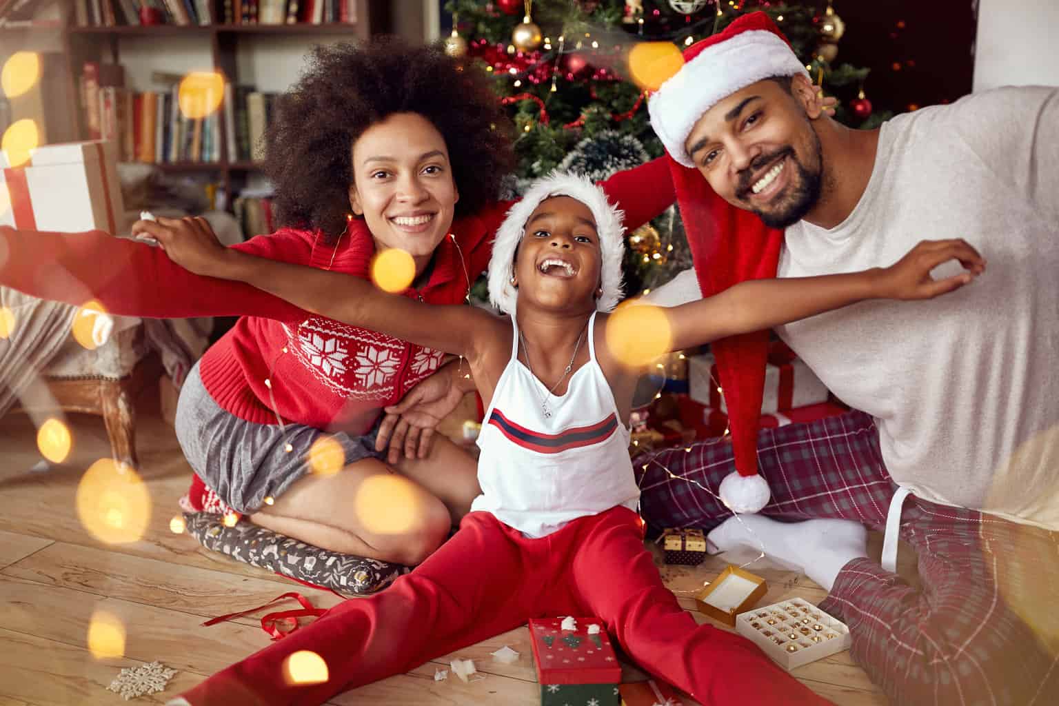 12 days of christmas activities for families, happy african american family in front of a christmas tree
